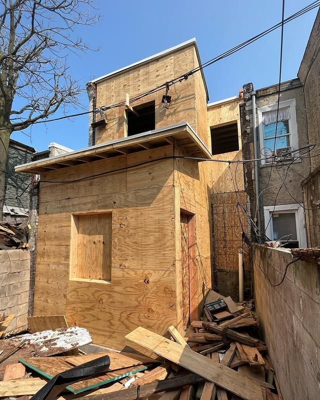 A small wooden house is being built in the backyard.