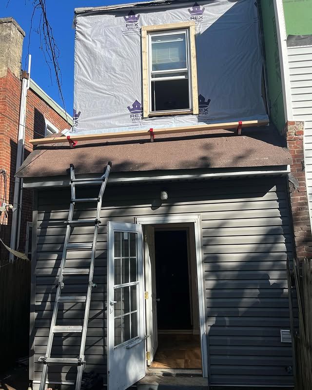 A ladder is sitting on the back of a house.