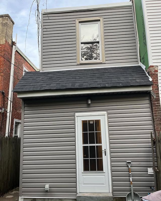 A small house with a shovel in front of it.