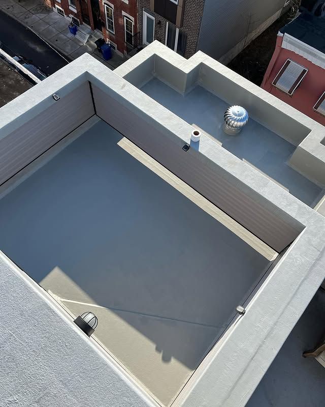 An aerial view of a rooftop deck with a skylight and a fan.