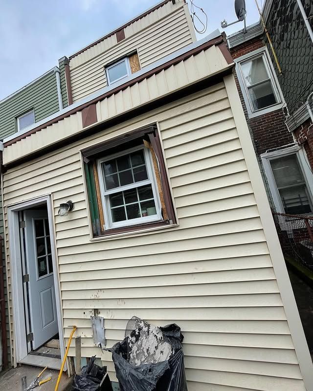 A house with a white siding and a window is being remodeled.