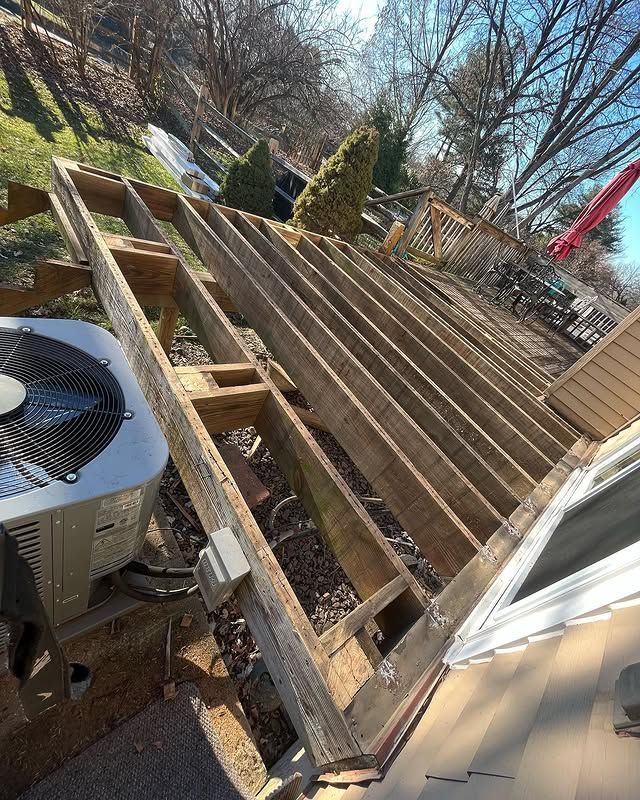 A wooden deck with a air conditioner on top of it.