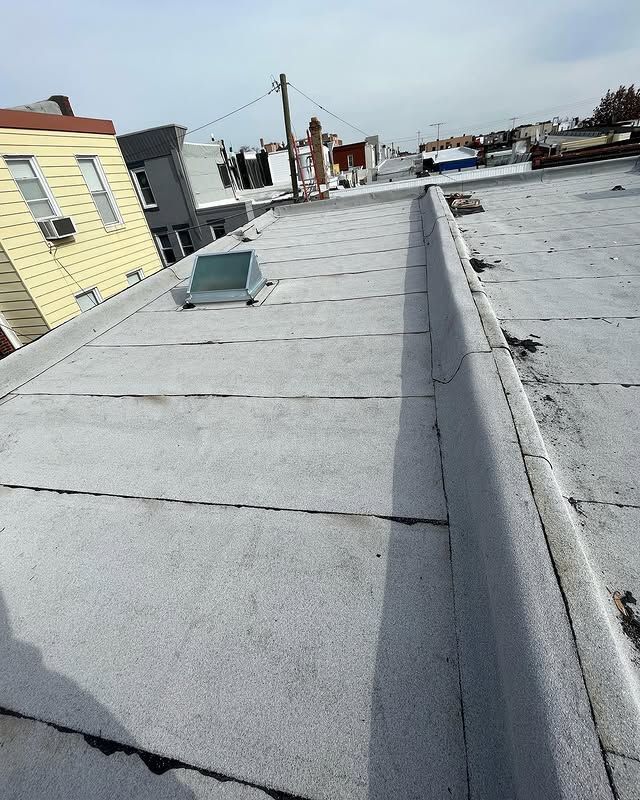 A white roof with a drain on the side of it