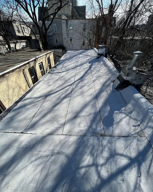A roof with trees in the background and a building in the background.
