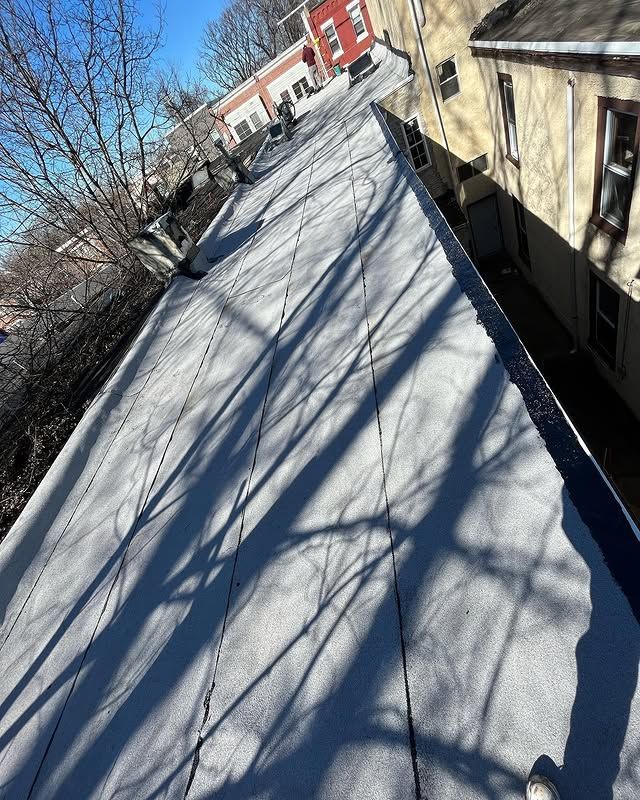 A roof with a lot of shadows on it and a building in the background.