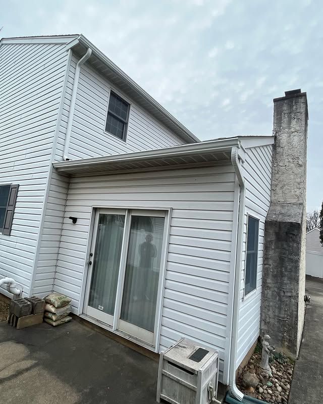 A white house with a sliding glass door and a chimney.