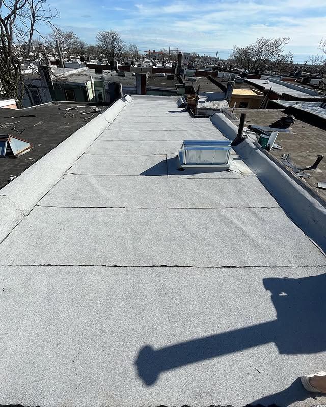 A person is standing on a roof with a shadow on it.