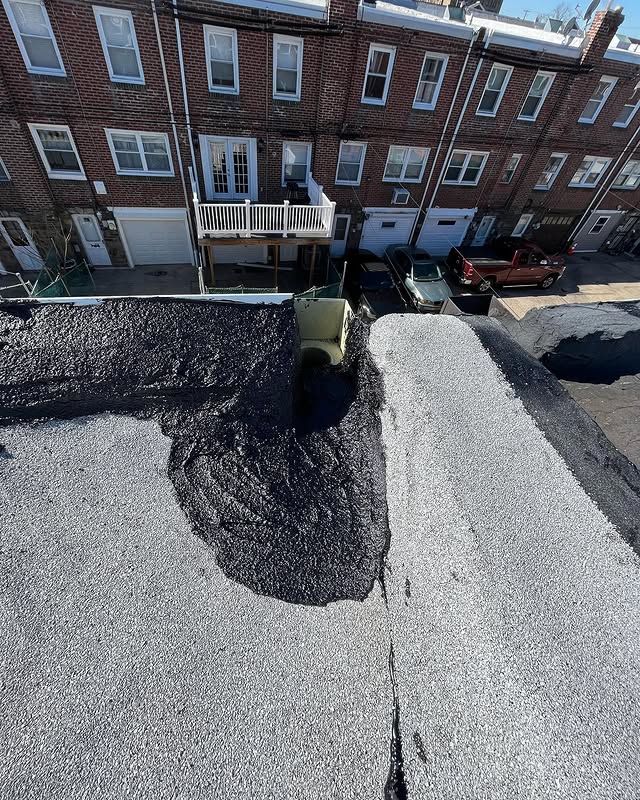 An aerial view of a roof with a brick building in the background.