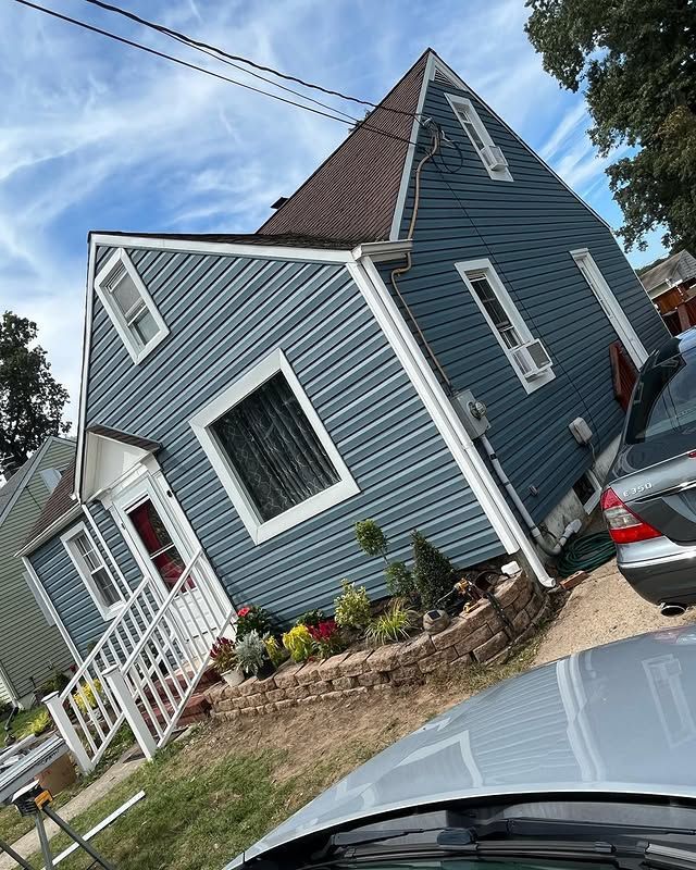 A blue house with a car parked in front of it.