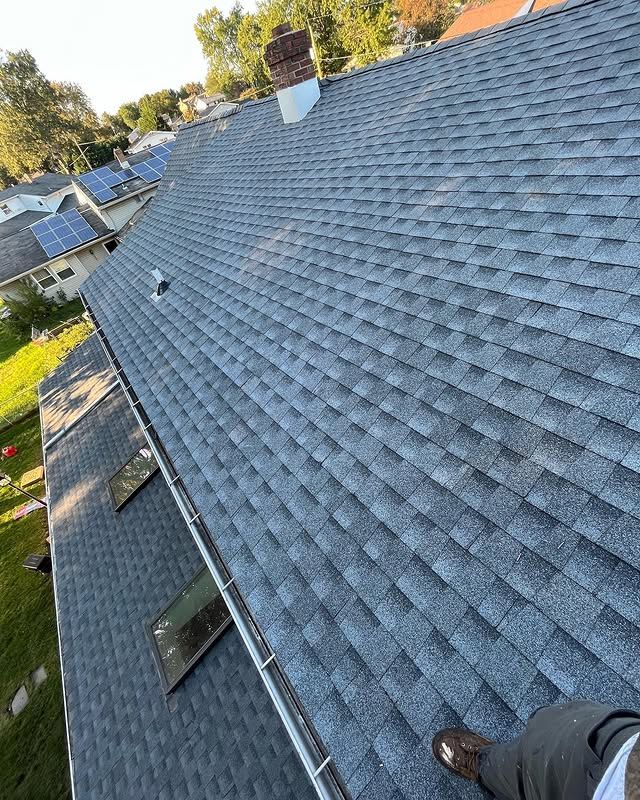 A person is standing on the roof of a house.
