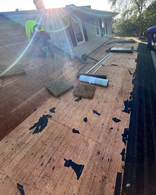 A man is working on the roof of a house.