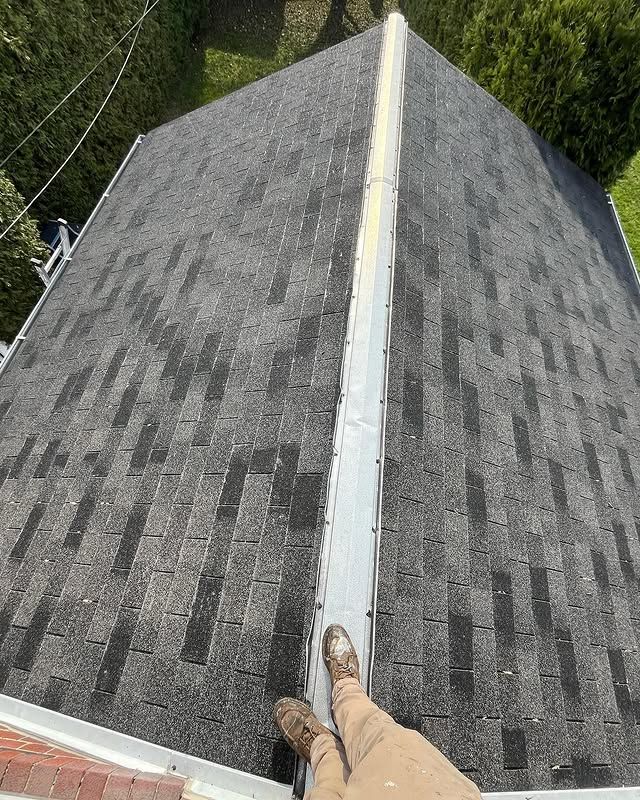 A person is standing on the roof of a house.