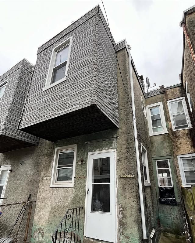 A house with a balcony on the side of it and a white door.