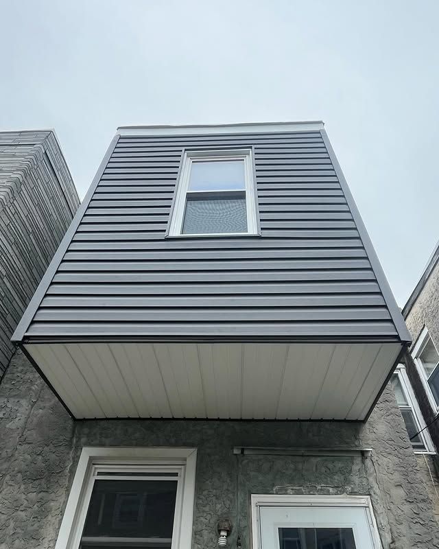 A house with a balcony and a window on the top of it.
