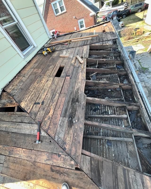 A wooden deck is being built on the roof of a house.