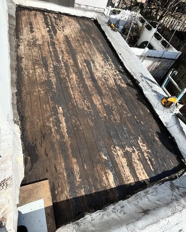 A wooden table is sitting on top of a white roof.