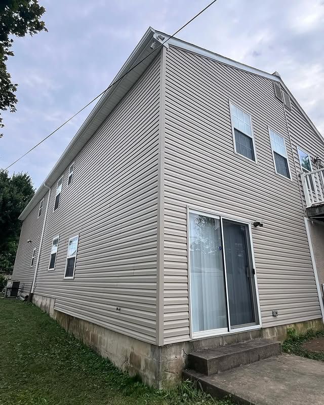 A large white house with a sliding glass door and stairs.