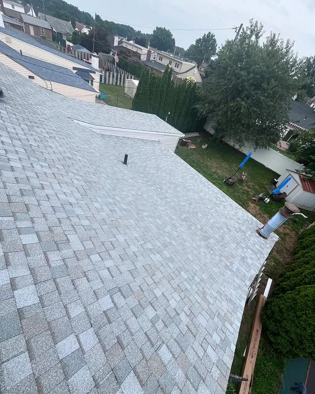 An aerial view of a roof with shingles being installed.