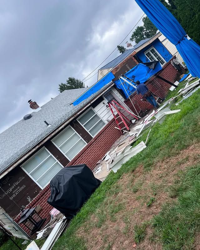 A house is being remodeled with a blue tarp on the roof.