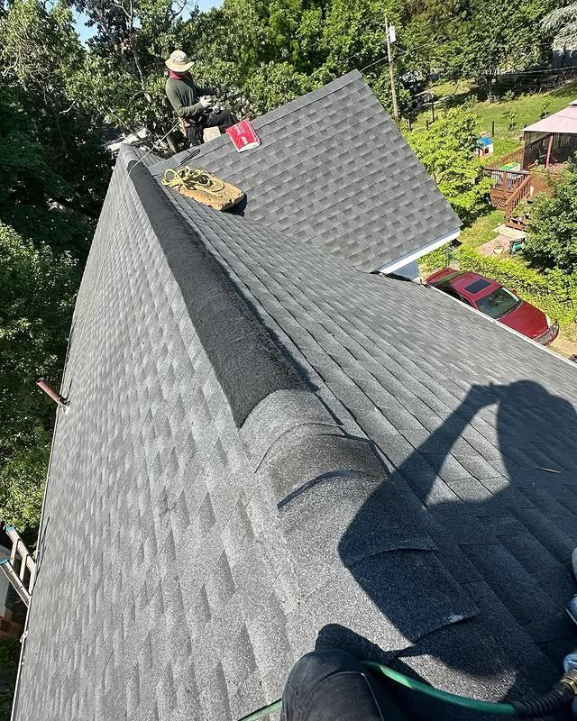 A man is sitting on top of a roof.
