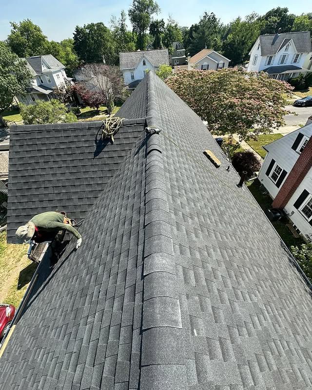 A man is working on the roof of a house.
