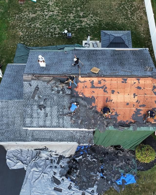 An aerial view of a house with a roof that is being repaired.