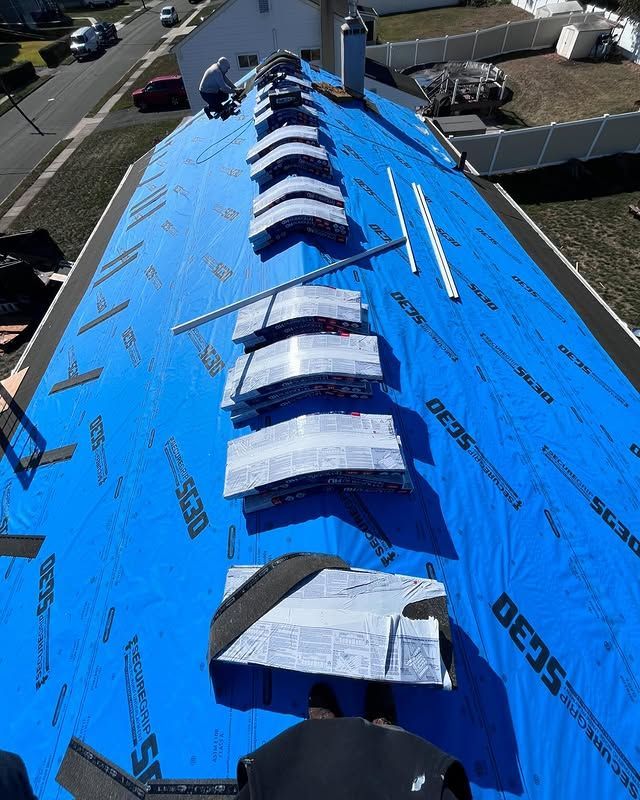 An aerial view of a roof with a blue roofing material that says scan