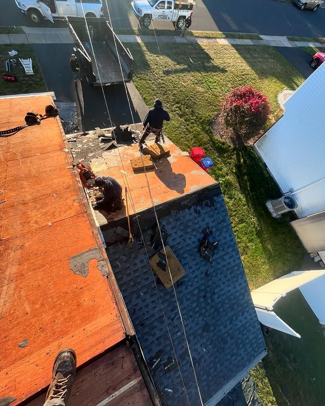 A group of people are working on the roof of a house.