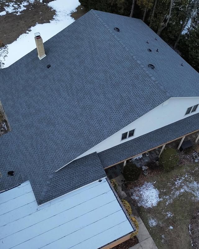 An aerial view of a house with a gray roof