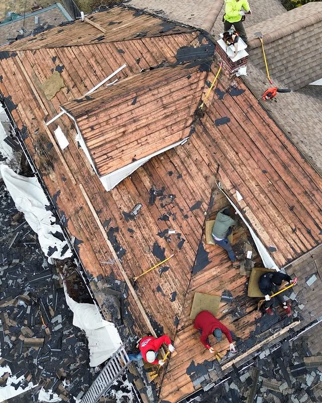 A group of people are working on a wooden roof.