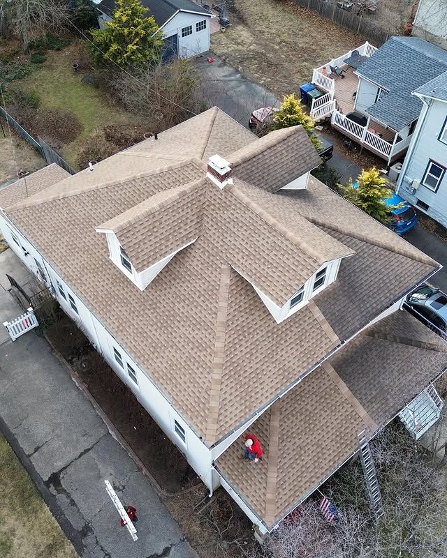 An aerial view of a house with a roof that is being repaired.