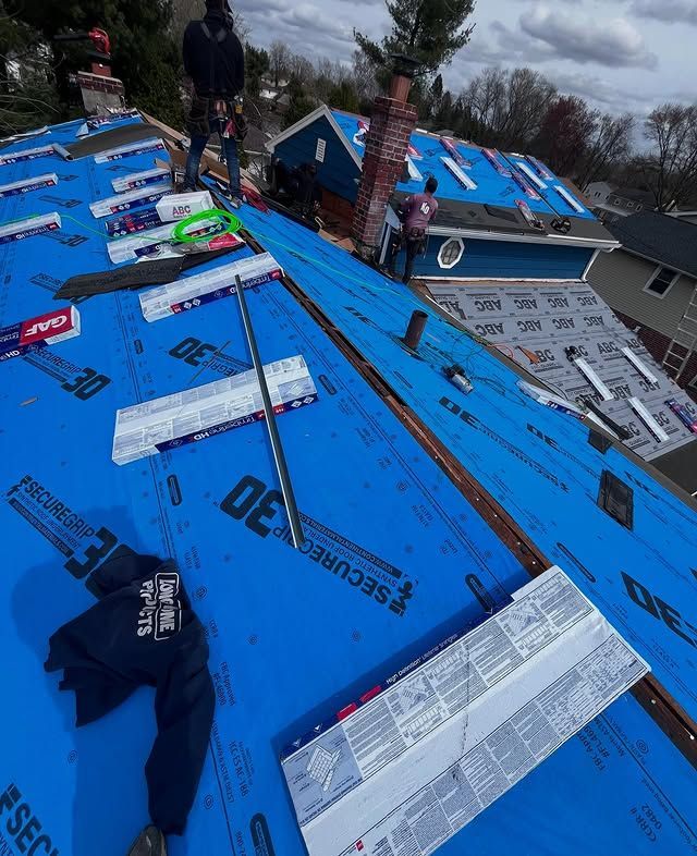 The roof of a house is covered in blue secure30 roofing paper