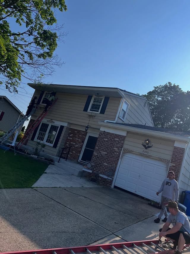 A group of men are working on the roof of a house.