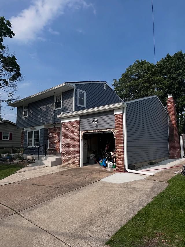 A house with a garage and a driveway in front of it.