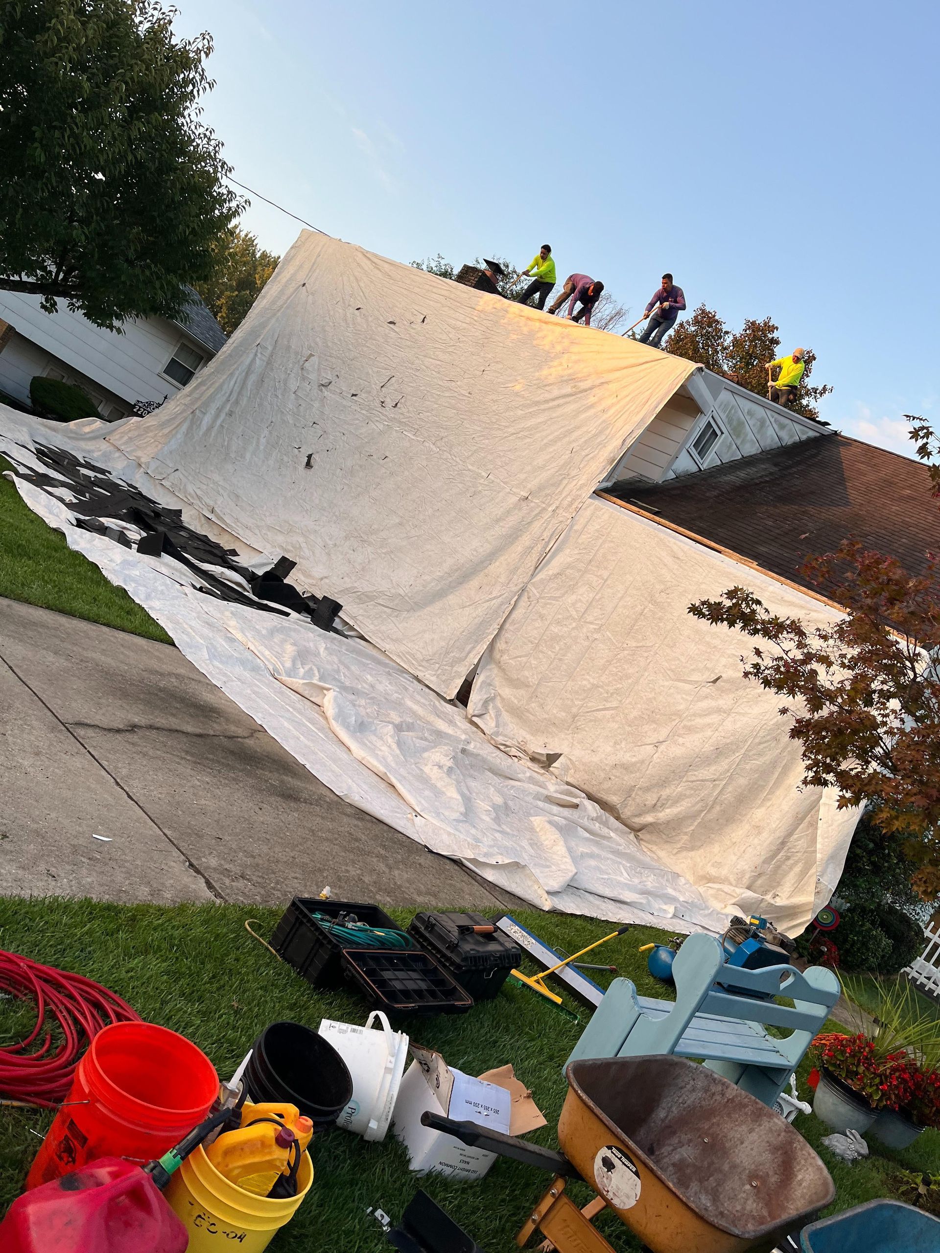 A group of people are working on the roof of a house.