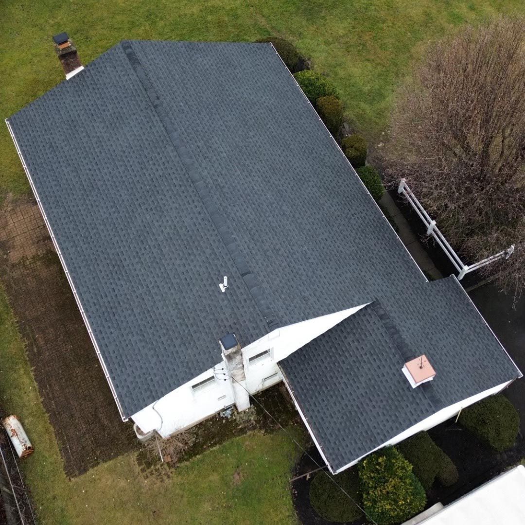 An aerial view of a house with a black roof.