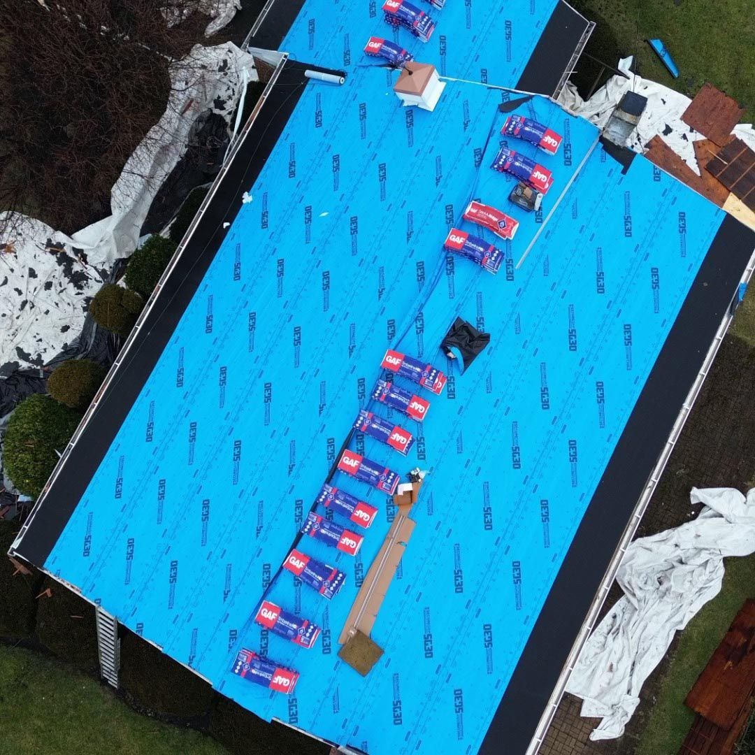 An aerial view of a roof with a blue tarp on it
