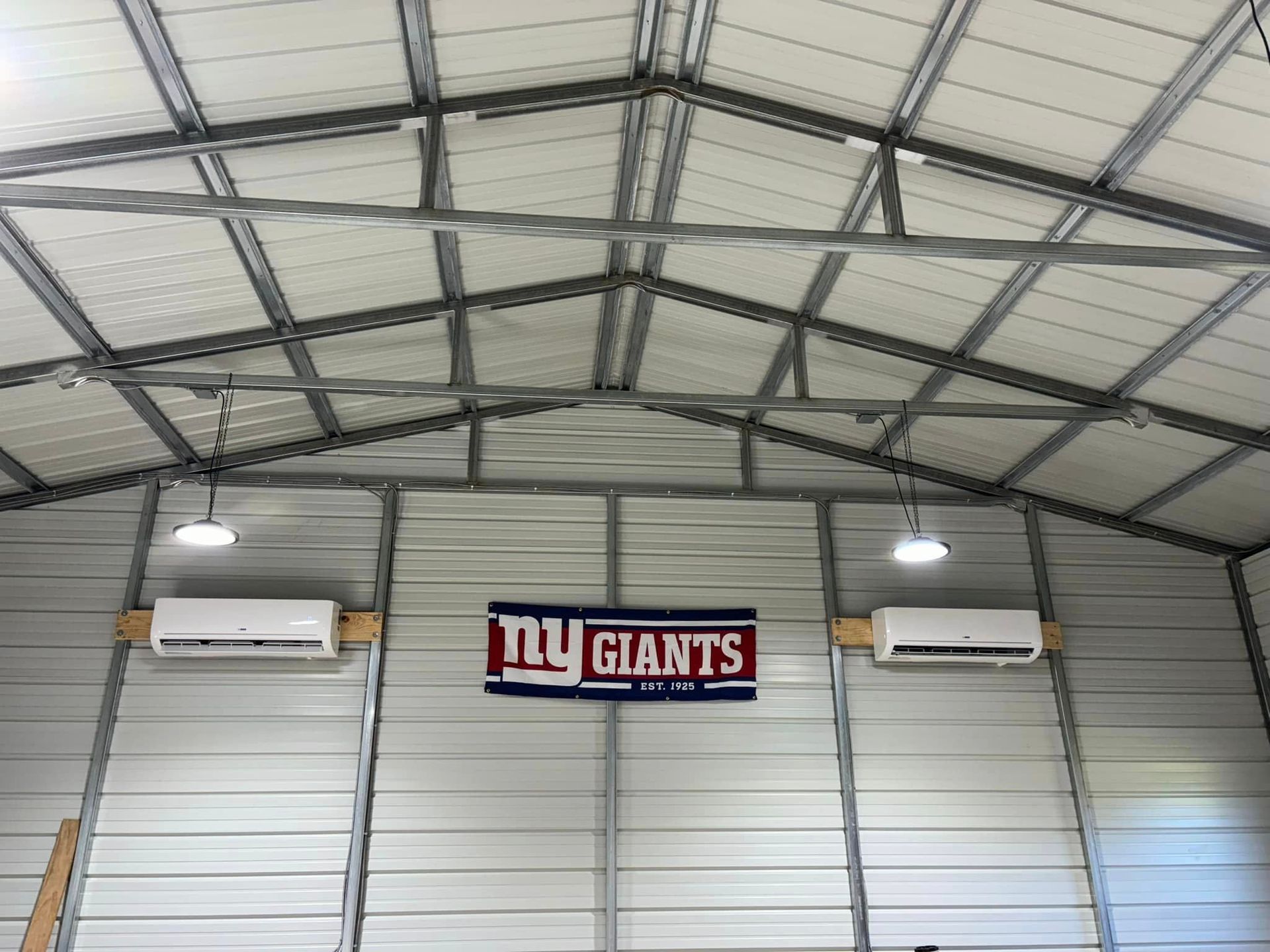 A sign for the new york giants hangs from the ceiling of a building.