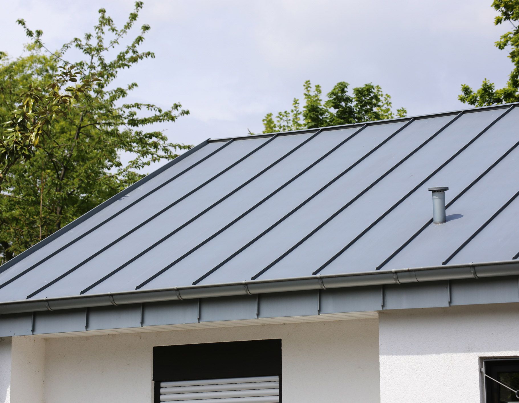 A white house with a gray roof and a window