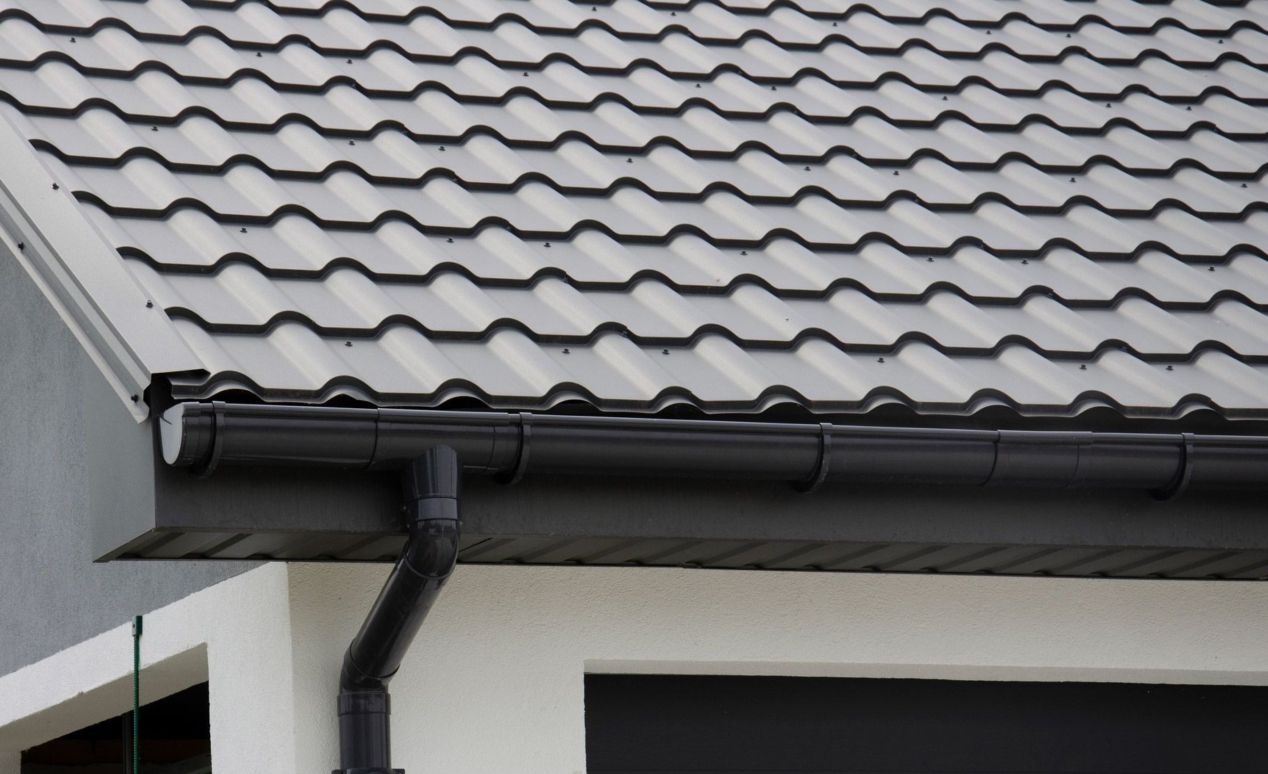 A close up of a gutter on a roof of a house.