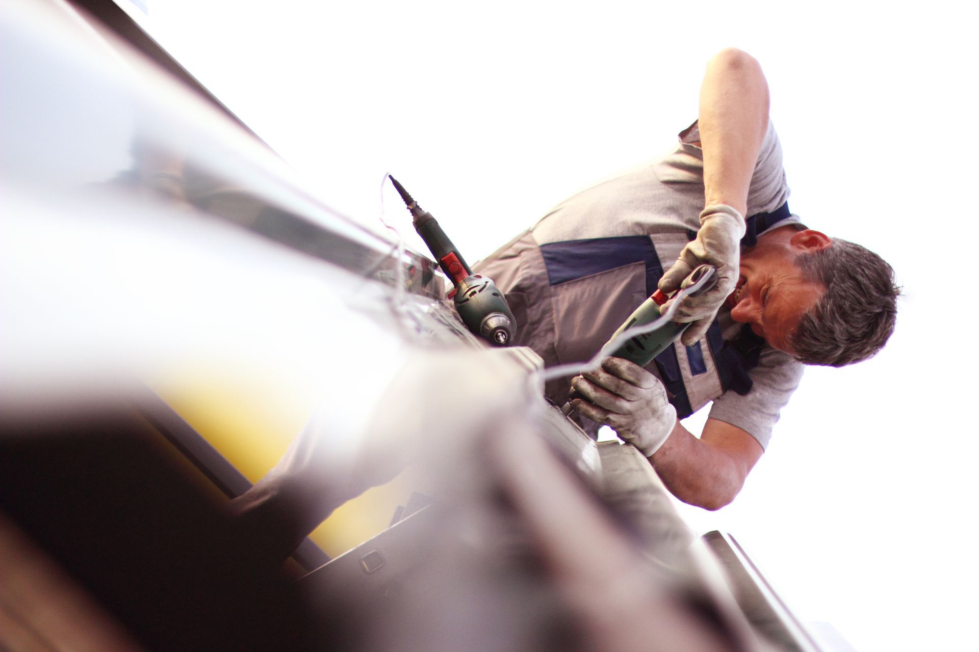 Construction workers conducting a roof repair of a metal roof.