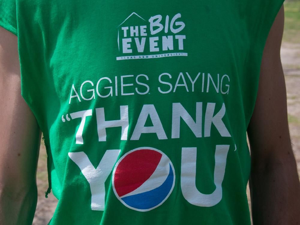 A person wearing a green shirt that says aggies saying thank you