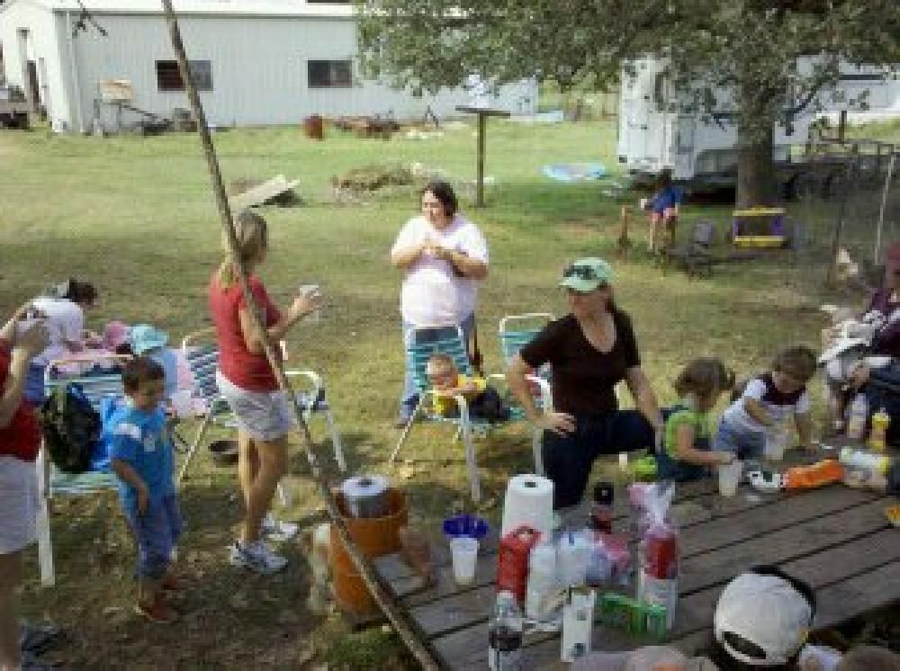 A group of people are gathered around a picnic table