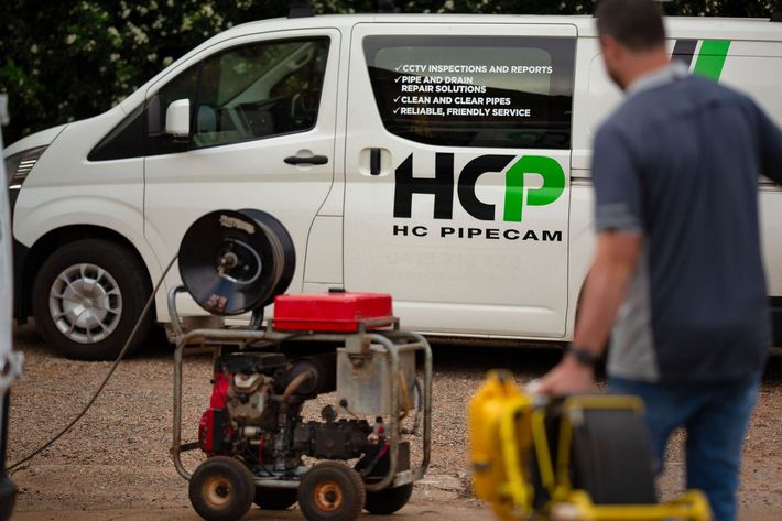 Plumber inspecting blocked drain using high pressure water jetting to clear blocked or slow drains, efficiently.