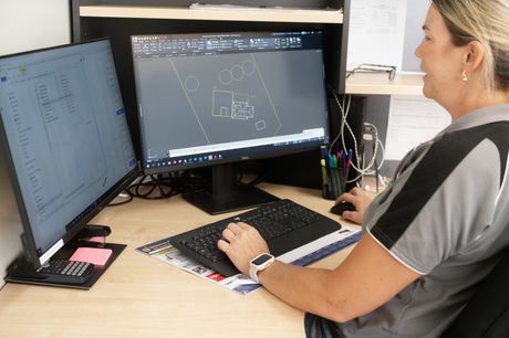 Picture of Kylie, our Designer/Drafter hard at work designing plans on her dual computer screens