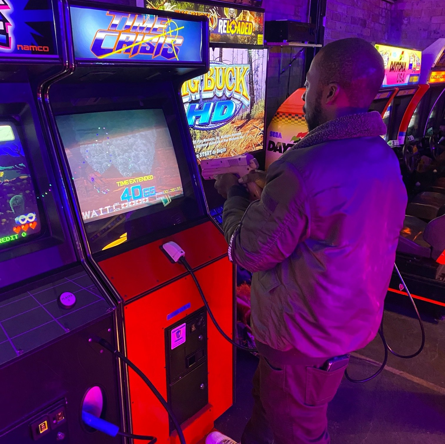 Man standing in front of an 80's video arcade game at Flipp'd Toowoomba