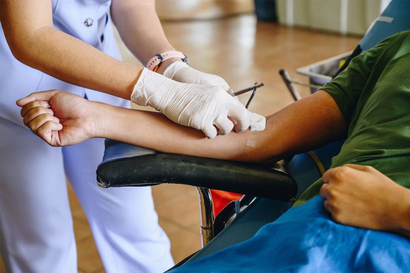 A nurse drawing blood sample from a patient.