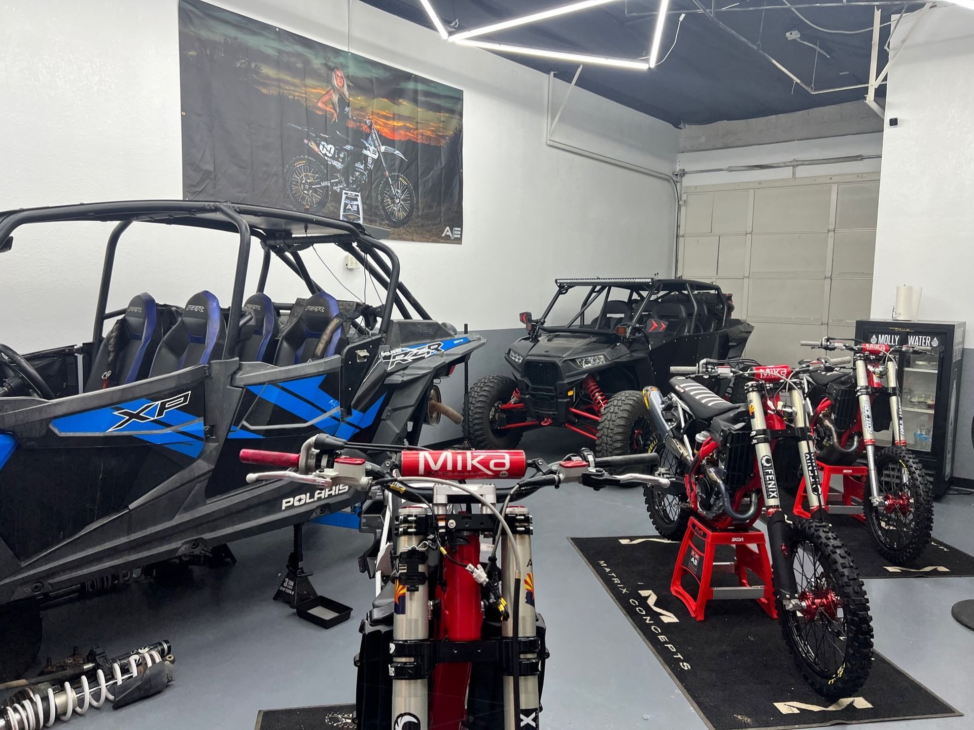 A garage filled with motorcycles and atvs.