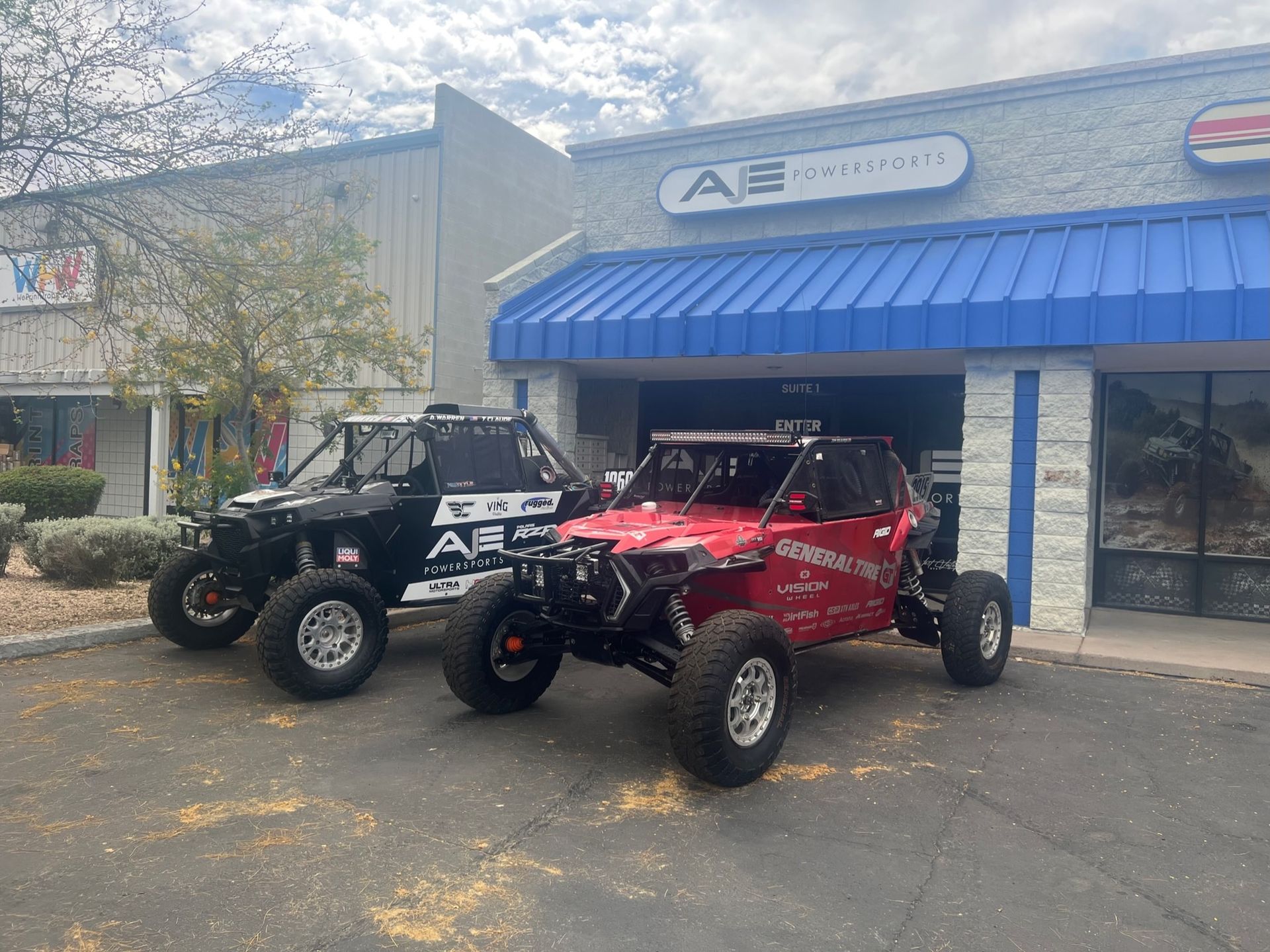 Two atvs are parked in front of a building.