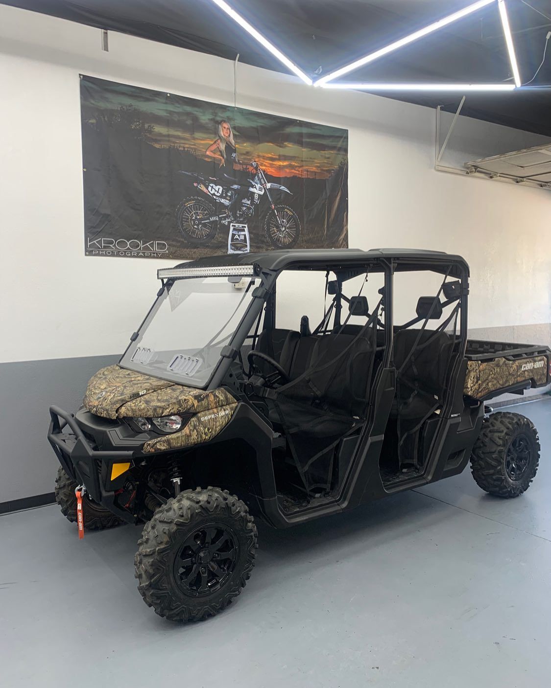 A can am defender max is parked in a garage.